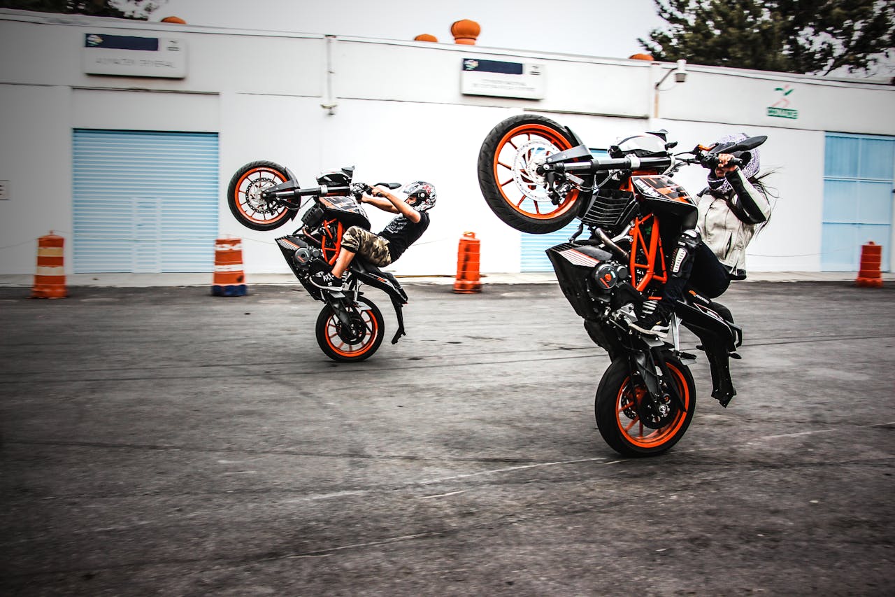 The Art of Drawing Readers In: Your attractive post title goes here Two motorcyclists performing wheelies on a road in Mexico City, showcasing thrilling stunts.